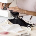 mains de femme en train de coudre avec une machine à coudre