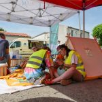 deux personnes lisent un livre à côté d'un tipi pour enfant